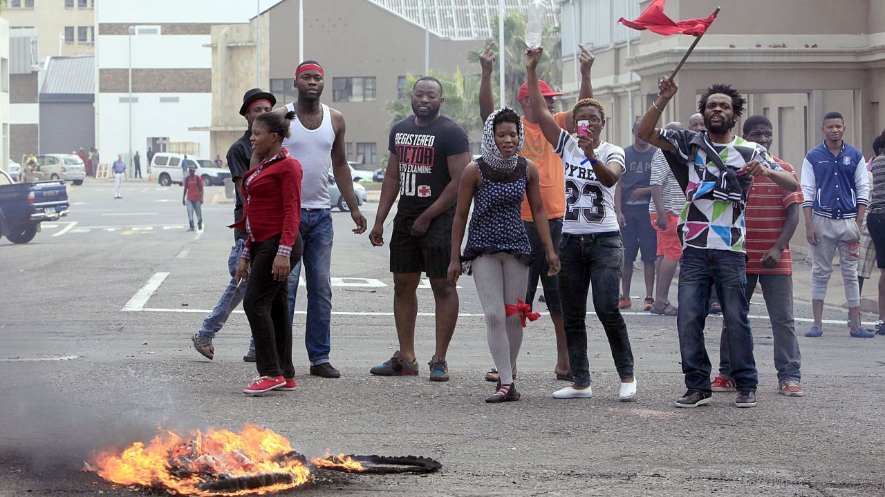 Foreign nationals gesture after clashes break out between a group of locals and police in Durban on April 14, 2015 in ongoing violence against foreign nationals in Durban.