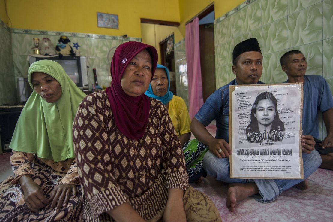 Family members of Indonesian maid Siti Zainab hold a poster of her  at their home in Bangkalan in East Java, April 15, 2015.