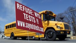 A school bus passes a sign encouraging parents to refuse that their children take state tests on Monday, April 13 in Rotterdam, N.Y. With standardized English tests set to begin Tuesday in New York schools, some parents are again planning to have their children sit out the exams. 