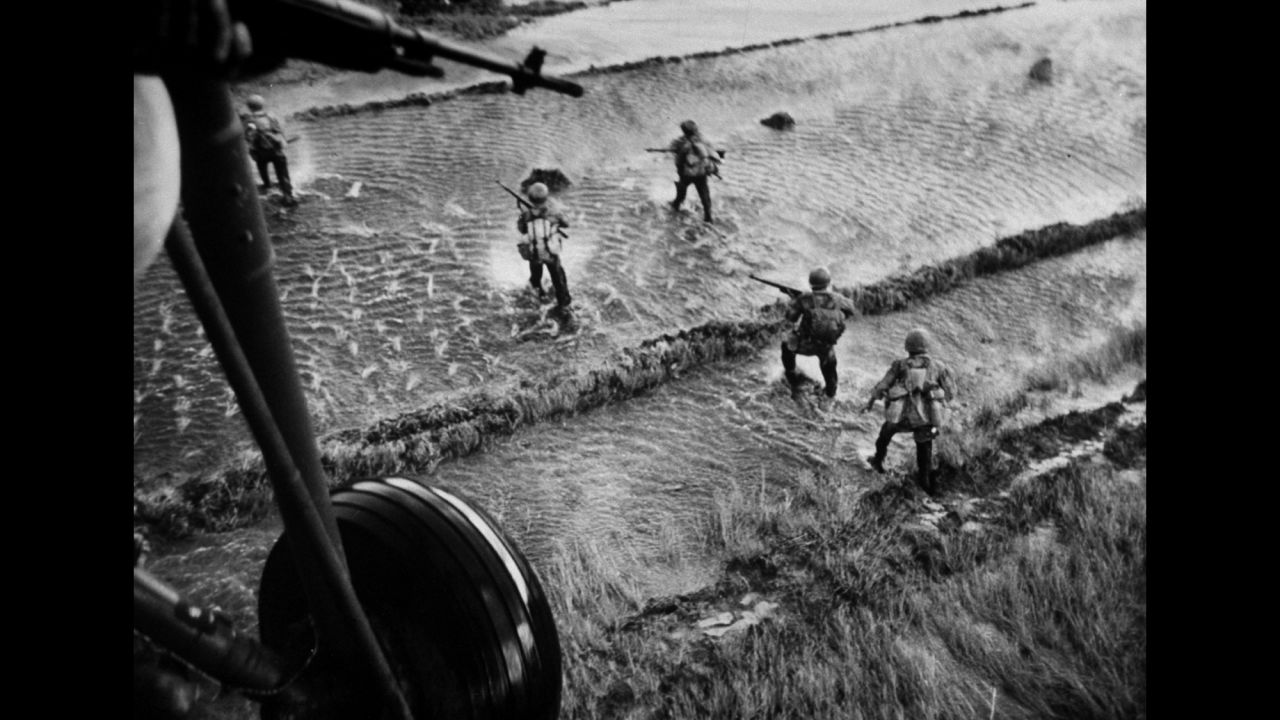 South Vietnamese troops wade through water to flush out communist rebels, known as the Viet Cong, in 1962. Several years earlier, North Vietnamese communists began helping the Viet Cong fight South Vietnamese troops. They wanted to overthrow the South Vietnamese government and reunite the country, which split in 1954.
