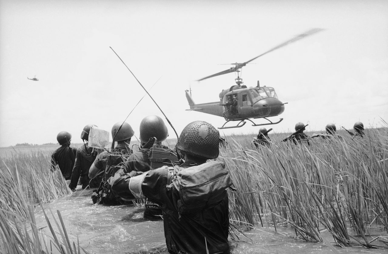 A South Vietnamese reconnaissance unit walks hip-deep in water as a U.S. helicopter skims over reeds in the Mekong Delta in October 1964. They were on the lookout for Viet Cong guerrillas.