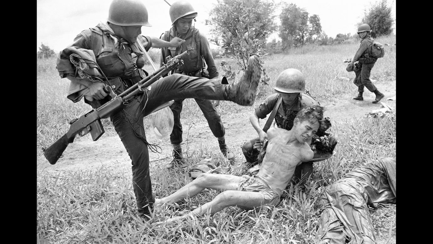 A suspected Viet Cong is kicked by a South Vietnamese soldier in October 1965. The prisoner was one of 15 captured in a raid near Xom Chua.