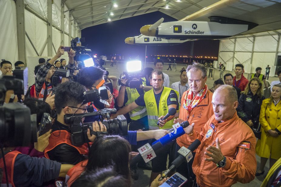 Borschberg and Piccard are welcomed by a crowd of reporters after landing in Chongqing.