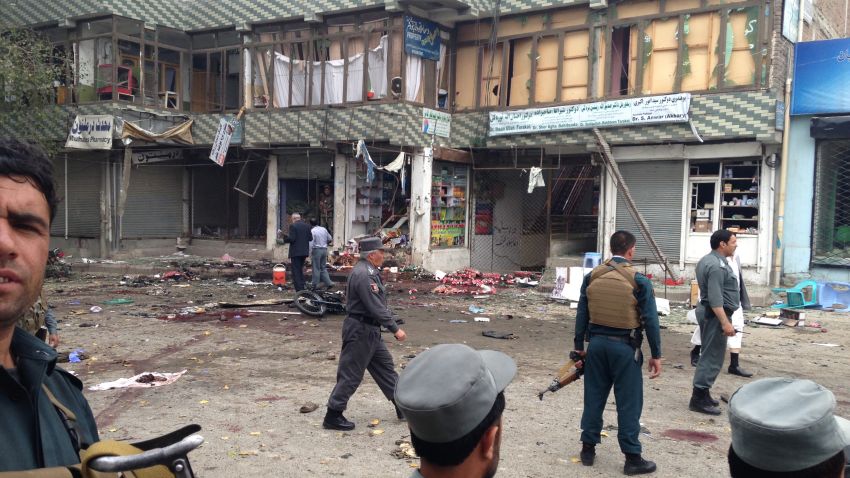 Afghan security forces inspect the site of a suicide attack near a bank branch in Jalalabad, east of Kabul, Afghanistan, Saturday, April 18, 2015. The suicide bomb attack on the bank branch has killed dozens of people, officials said. (AP Photo)
