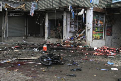 A member of Afghanistan's security forces stands at the site where a suicide bomber on a motorbike blew himself up in front of the Kabul Bank in Jalalabad, Afghanistan, on Saturday, April 18. ISIS claimed responsibility for the attack. The explosion killed at least 33 people and injured more than 100 others, a public health spokesman said.