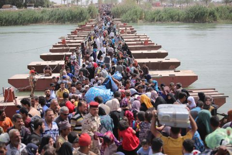 Thousands of Iraqis cross a bridge over the Euphrates River to Baghdad as they flee Ramadi on Friday, April 17.