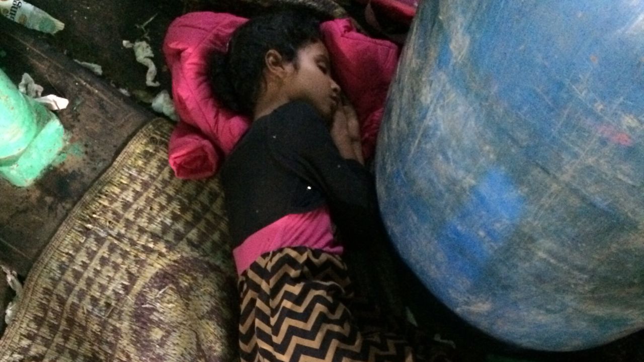 Muna's grandchild sleeps curled around an oil drum during the journey from Aden to Djbouti.