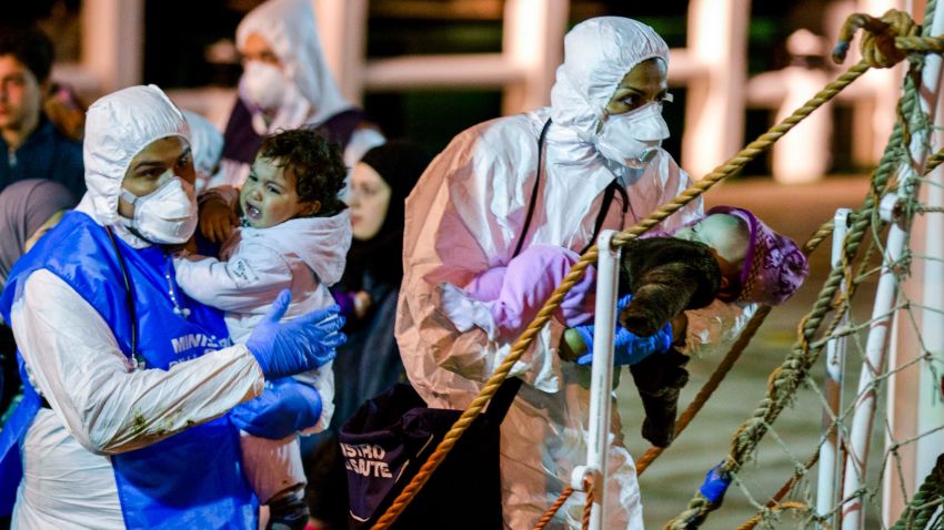 Rescuers help children to disembark in the Sicilian harbor of Pozzallo, Italy, early Monday, April 20, 2015. About 100 migrants, including 28 children, were rescued on Sunday by a merchant vessel in the Sicilian Strait while they were trying to cross. Another smuggler's boat crammed with hundreds of people overturned off Libya's coast on Saturday as rescuers approached, causing what could be the Mediterranean's deadliest known migrant tragedy and intensifying pressure on the European Union Sunday to finally meet demands for decisive action. (AP Photo/Alessandra Tarantino)