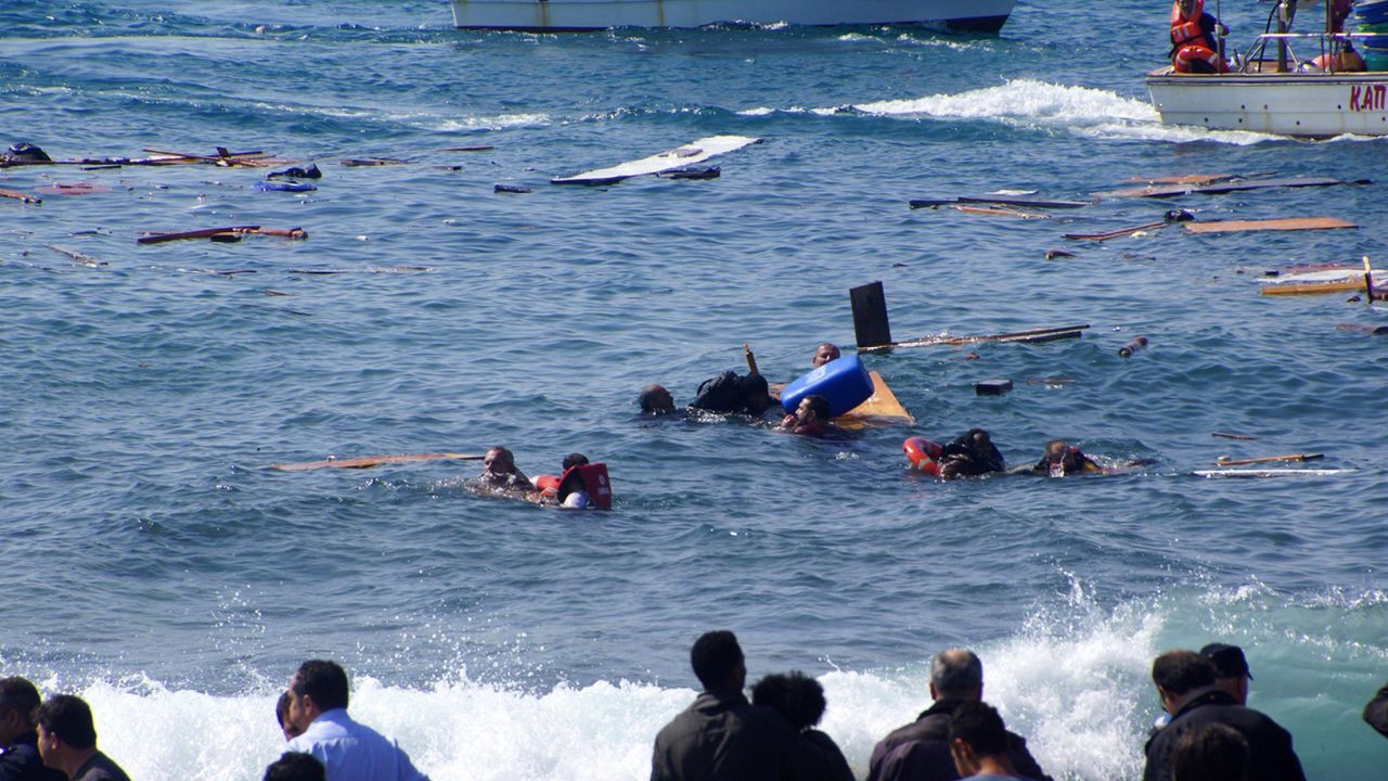 Local residents and rescue workers try to help migrants after their boat sank off the island of Rhodes, southeastern Greece, on April 20, 2015. At least three people, including a child, died when a boat carrying more than 80 migrants sank off the Greek island of Rhodes on Monday, police said. 