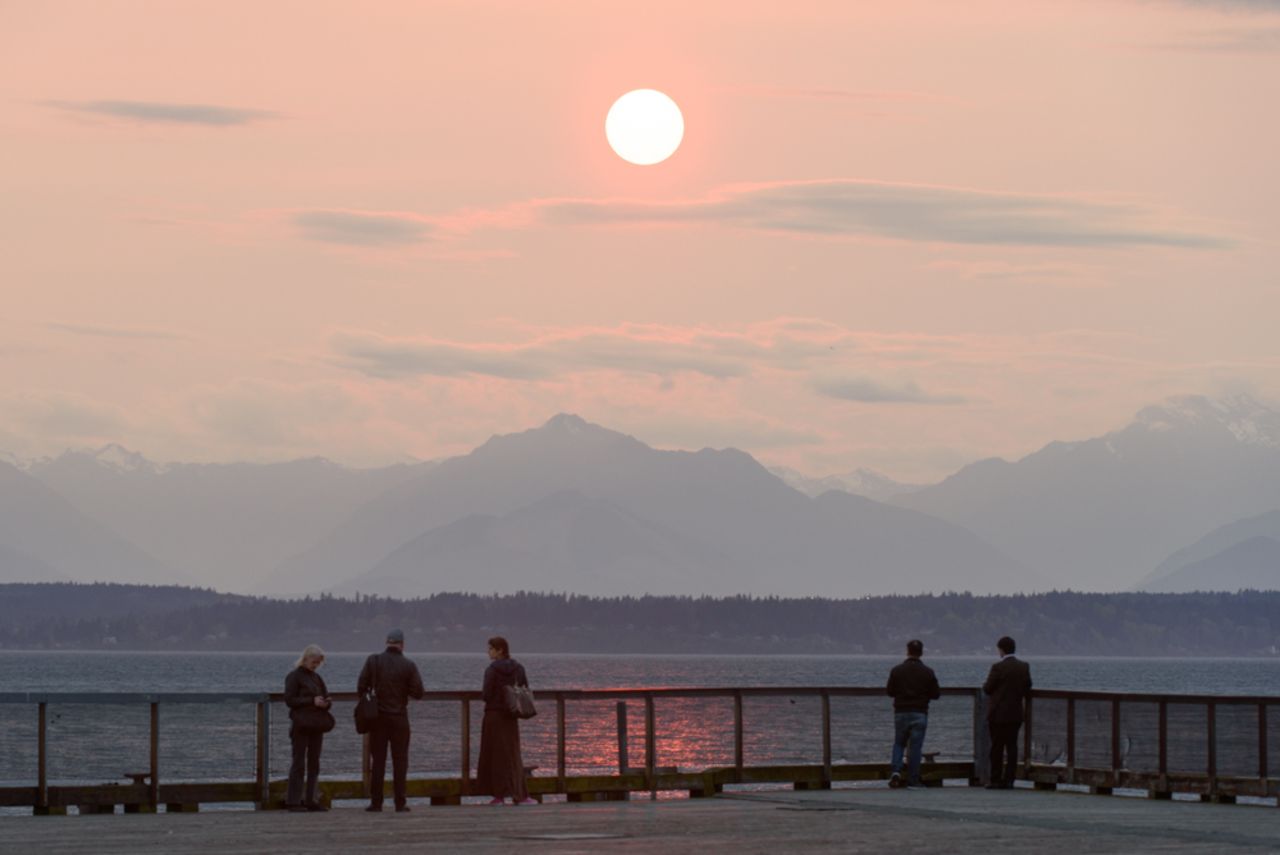 People in Seattle gather on a boardwalk to admire the sunset on Sunday.