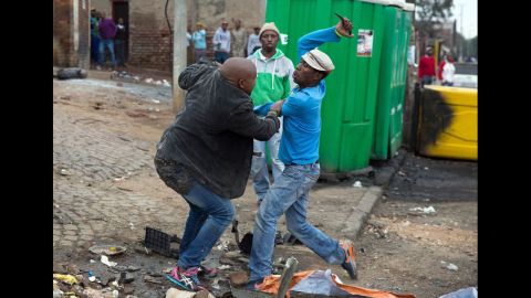 Mozambican Emmanuel Sithole, left, was walking down a street in Johannesburg's Alexandra Township when four men surrounded him on Saturday, April 18. Sithole pleaded for mercy, but it was already too late. The attackers bludgeoned him with a wrench and stabbed him with knives, killing him in broad daylight. Photographer James Oatway was nearby and captured it all on his camera.