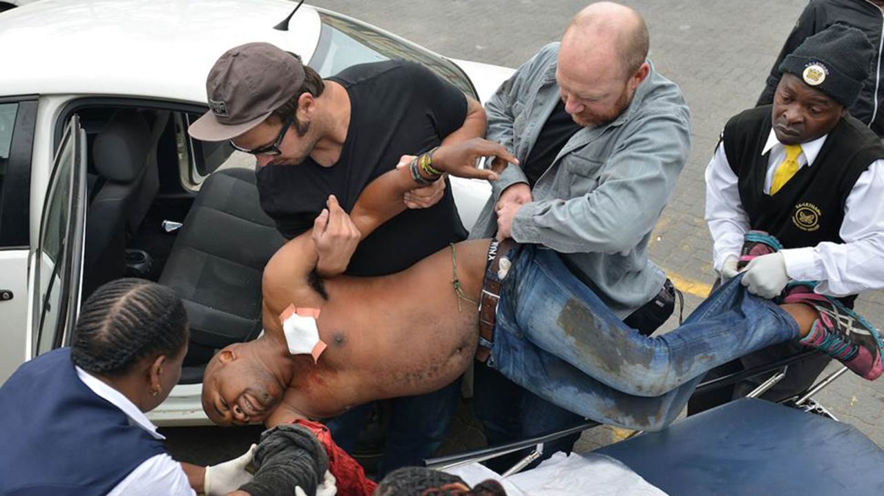 Another photographer, Antoine de Ras, captured the moment Oatway and local authorities assisted the victim. Oatway is the one holding Sithole's belt.