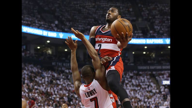 Washington's John Wall leaps into Toronto's Kyle Lowry as he drives to the basket Saturday, April 18, during Game 1 of their Eastern Conference playoff series. Wall and the Wizards defeated the Raptors 93-86 in overtime.