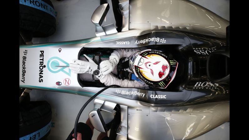 Formula One driver Lewis Hamilton adjusts his suit Friday, April 17, as he prepares for the Bahrain Grand Prix in Sakhir, Bahrain. He won the race two days later.