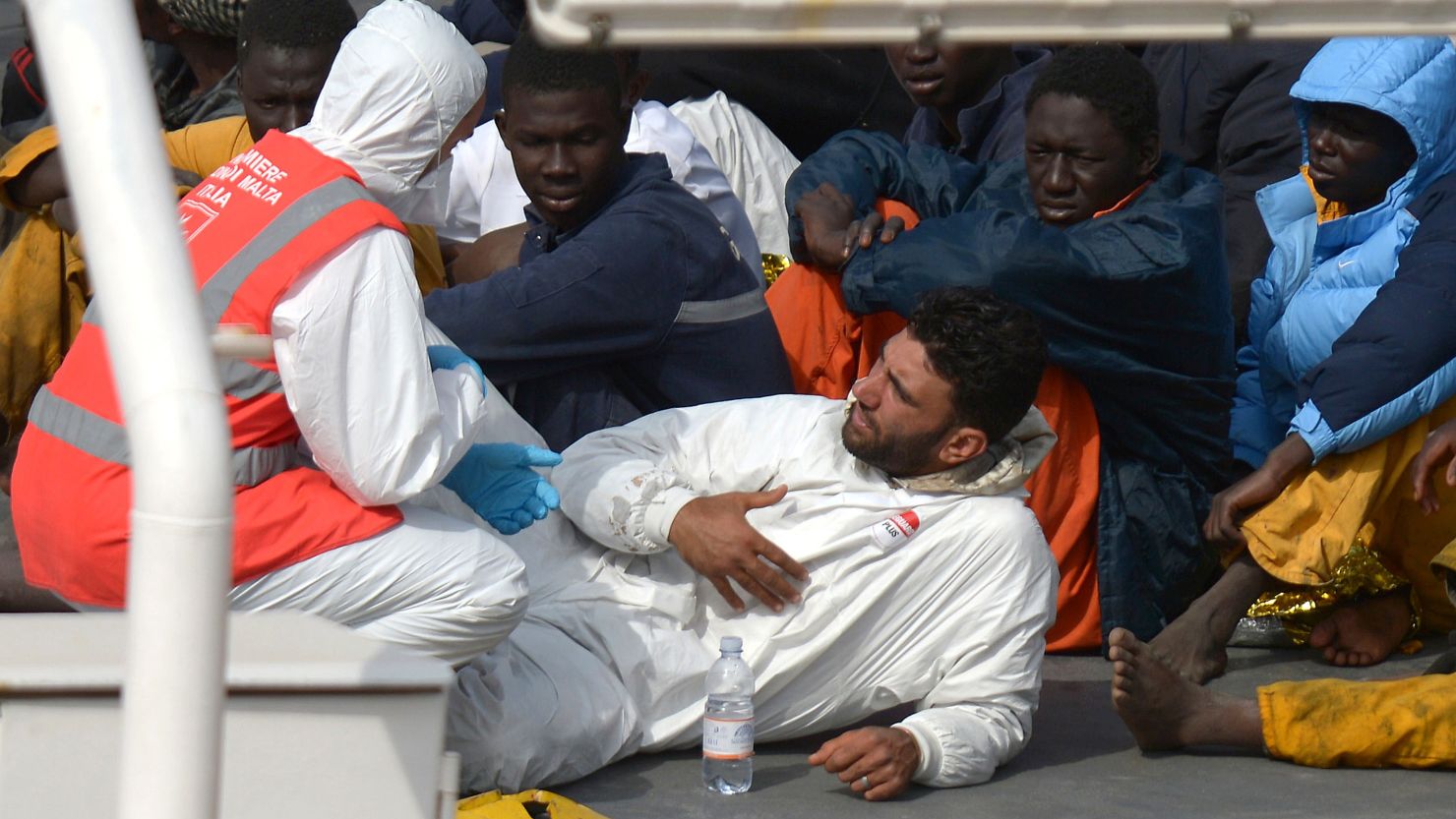 Rescued migrants talk to a member of the Malta Order after a fishing boat carrying migrants capsized off the Libyan coast on April 20, 2015. 