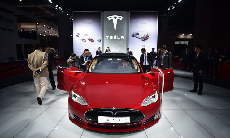 Visitors try out the driver's seat of a Tesla Model S P85D car displayed at the Shanghai Auto Show. The "D" stands for dual motor, which powers front and back wheels, giving it more oomph than the previous model. And it has a range of around 250 miles per charge.