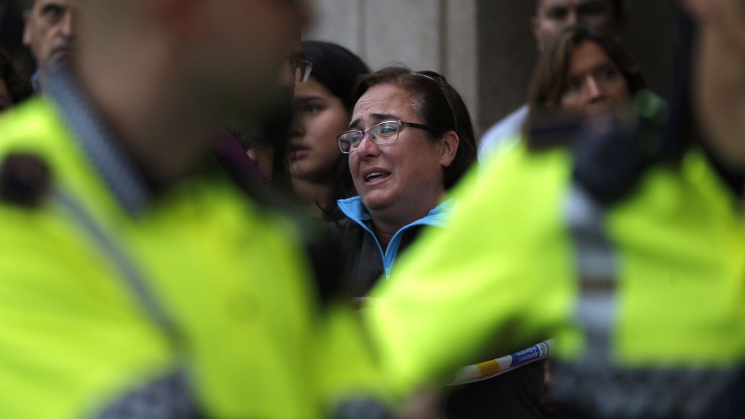 A woman reacts outside a high school in Barcelona after a teacher was killed.