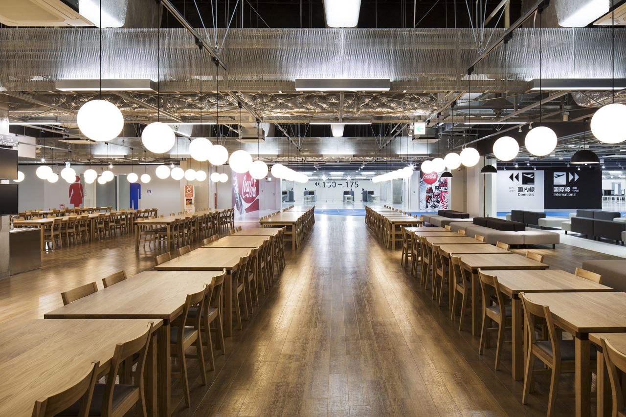 The open food court employs low-cost natural wood Muji furniture, but creates a modern, domestic feel in the heart of an airport departure lounge. 
