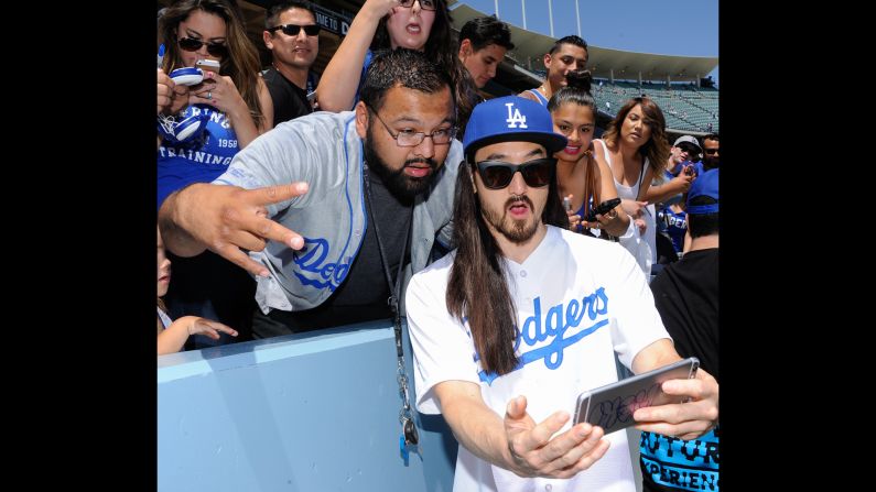 Musician Steve Aoki snaps a selfie with fans at a Los Angeles Dodgers baseball game on Sunday, April 19.