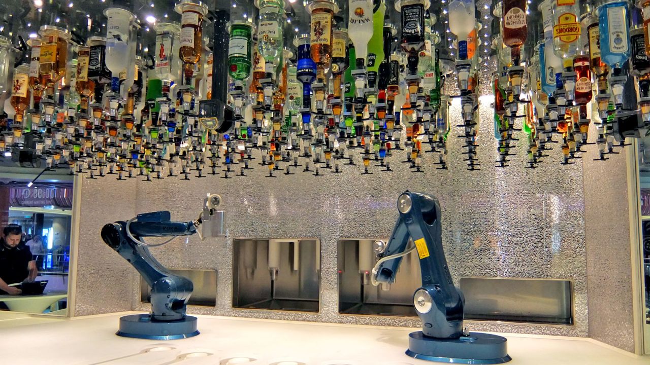 Bottles overhang the robot bartenders as they mix up tomorrow's hangovers.