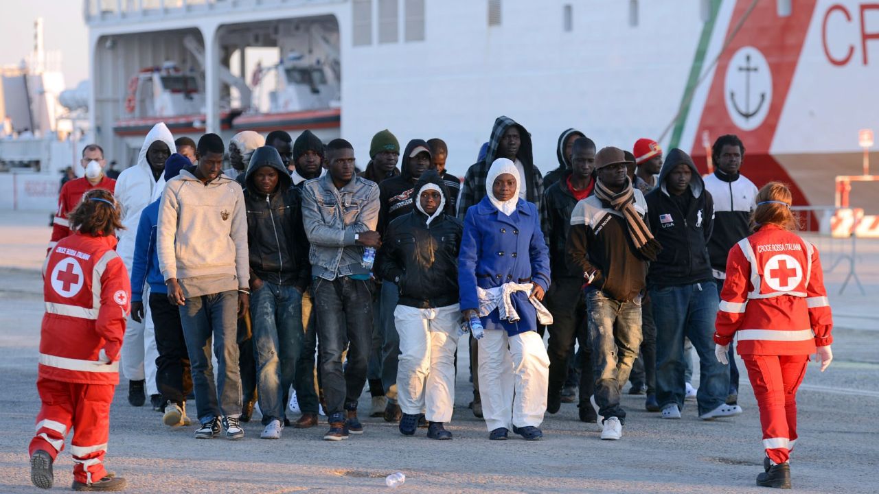 Shipwrecked migrants disembark from a rescue vessel as they arrive in the Italian port of Augusta in Sicily on April 16, 2015. As many as 41 migrants drowned after a small boat carrying refugees sank in the Mediterranean, Italian media said, days after 400 were lost in another shipwreck. Four survivors told Italian police and humanitarian organisations that their inflatable vessel sank not long after leaving the coast of Libya for Europe with 45 people on board. AFP PHOTO / GIOVANNI ISOLINO (Photo credit should read GIOVANNI ISOLINO/AFP/Getty Images)