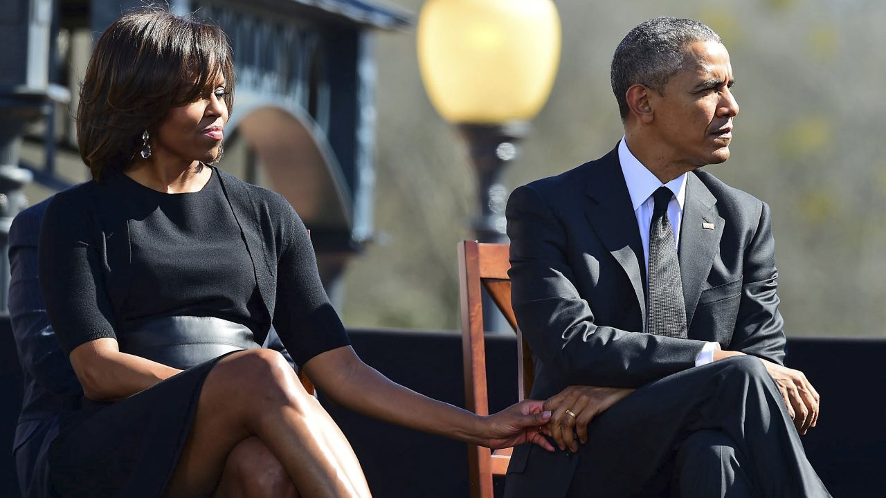 First lady Michelle Obama holds the hand of her husband during a ceremony marking 50 years since Bloody Sunday.
