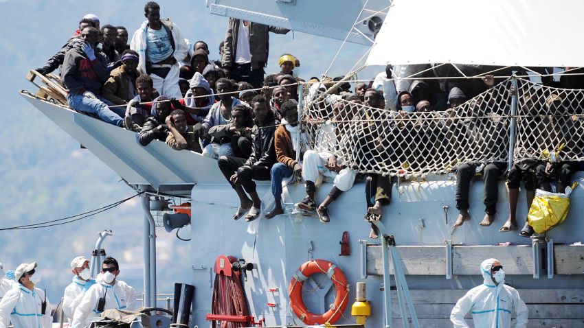 Migrants wait to disembark from the Italian Navy vessel 'Chimera' in the harbor of Salerno, Italy, Wednesday, April 22, 2015. Italy pressed the European Union on Wednesday to devise concrete, robust steps to stop the deadly tide of migrants on smugglers' boats in the Mediterranean, including setting up refugee camps in countries bordering Libya. Italian Defense Minister Roberta Pinotti also said human traffickers must be targeted with military intervention. (AP Photo/Francesco Pecoraro)