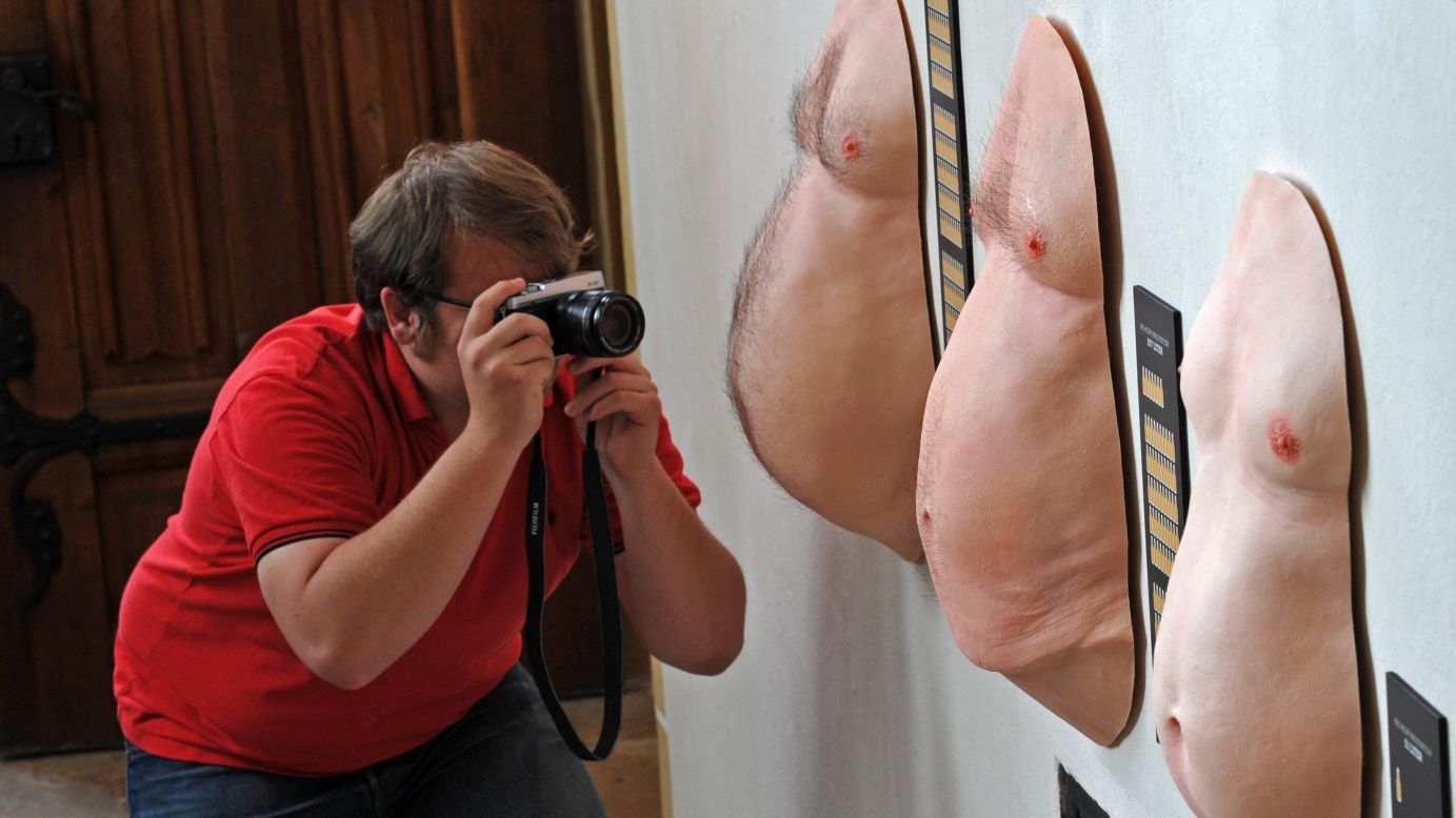 A man photographs the average beer bellies of the Saxons, left; the Germans, center; and the Hessians in a new exhibit Friday, April 17, in Meissen, Germany. The exhibit, "Prost! 1,000 Years of Beer in Saxony," is on display at the Albrechtsburg until November.