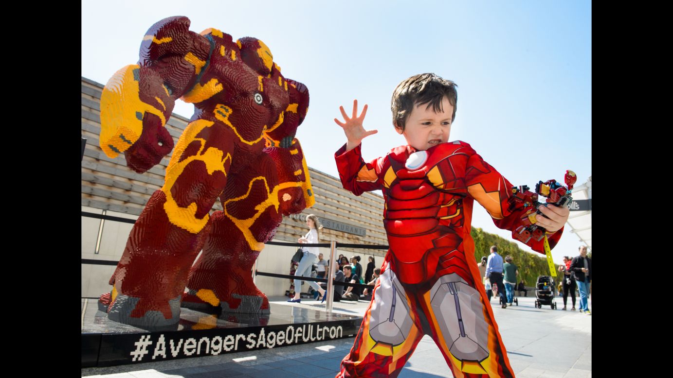 A boy dressed as Iron Man poses in front of a Lego statue of the superhero Tuesday, April 21, in London's Westfield Shopping Center. The Lego statue is more than 8 feet tall and weighs a ton. It took six professional builders 960 hours to create.