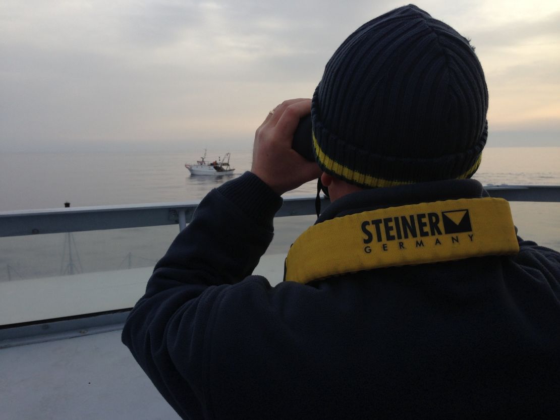 A police officer keeps watch for migrants off Lampedusa, Italy.