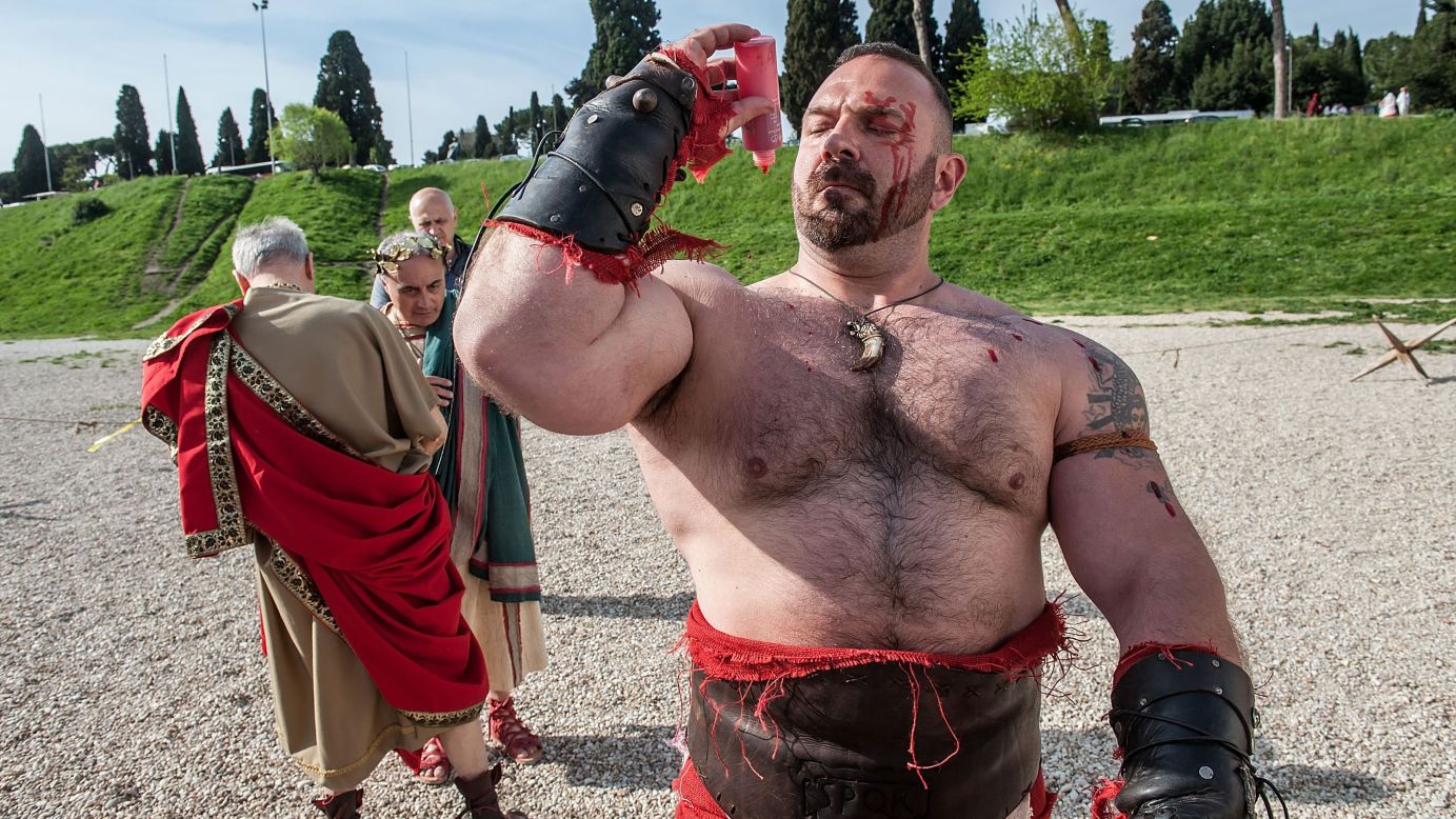 An actor dressed as an ancient gladiator puts fake blood on himself as he gets ready for a parade marking Rome's anniversary on Sunday, April 19.