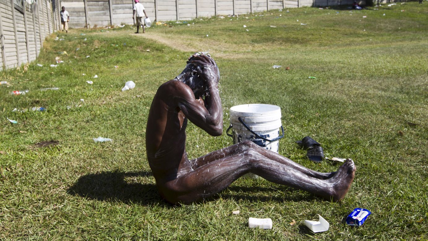 A man bathes on a sports field Tuesday, April 21, in Durban, South Africa, adjacent to a camp for those affected by anti-immigrant violence. South Africa has deployed its army in "volatile areas" to curb a wave of anti-immigrant violence that has killed at least seven people this month, the defense minister said.