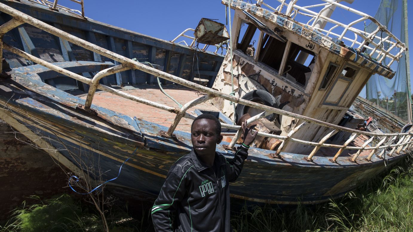Eric Joseph, a migrant from Nigeria, stands in a "boat graveyard" by the port in Lampedusa, Italy, on Wednesday, April 22. Joseph left Libya on a vessel and spent 21 hours at sea before being picked up by the Italian Coast Guard and brought to Lampedusa. <a href="http://www.cnn.com/2015/04/21/world/gallery/europe-migrant-crisis/index.html" target="_blank">Hundreds of migrants are believed to have died this month</a> as they attempted to cross the Mediterranean Sea to seek refuge in Italy.