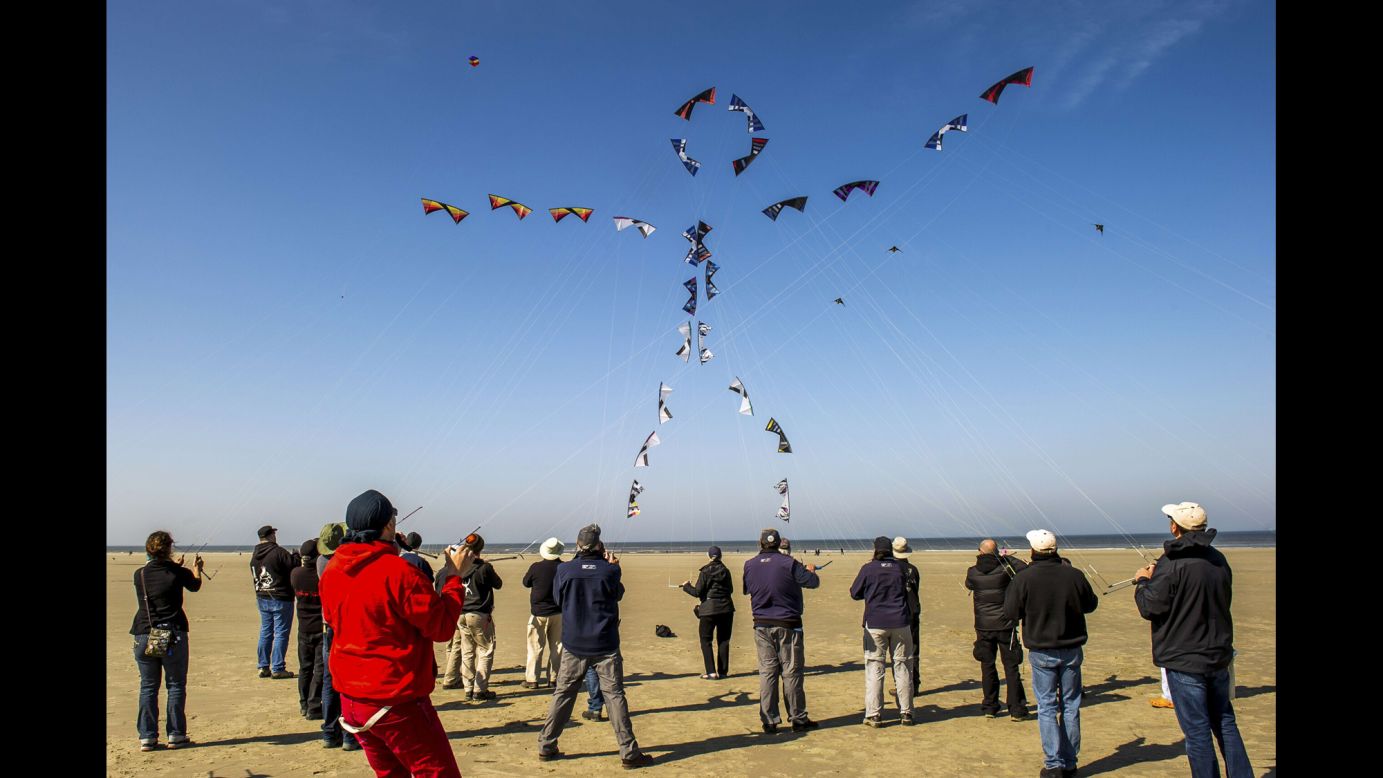 People in Berck, France, fly their kites to form the shape of a stick figure on Monday, April 20, during the annual International Kite Meeting.