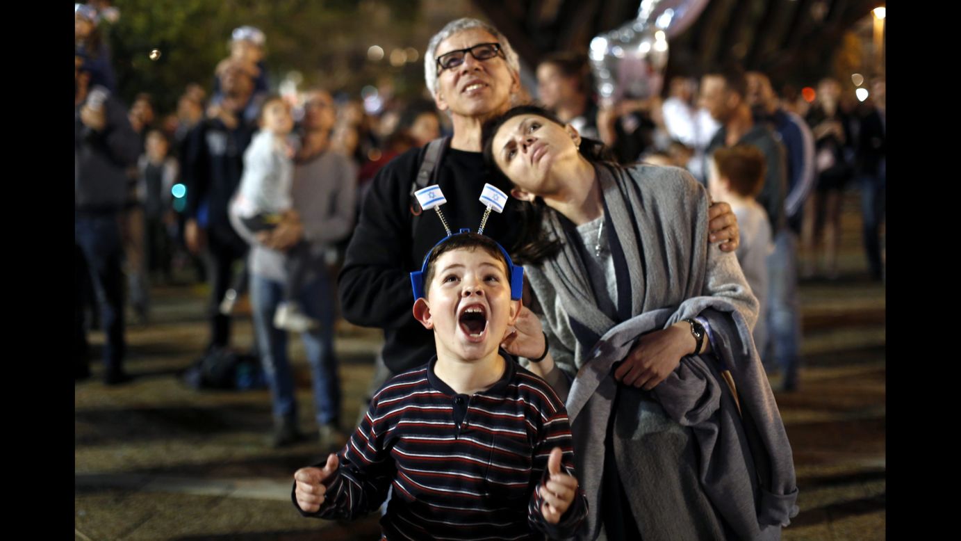 A boy watches fireworks with his parents during Independence Day celebrations in Tel Aviv, Israel, on Wednesday, April 22.