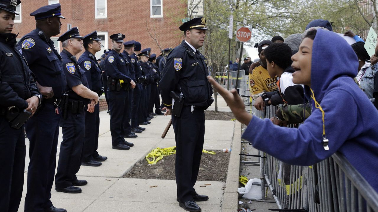 Members of the Baltimore Police Department stand guard Thursday, April 23, outside the department's Western District station during a protest.