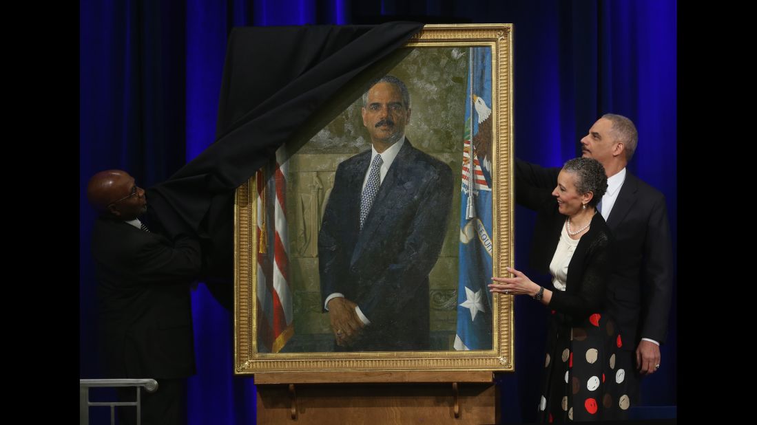 Holder and his wife, Sharon Malone, look on as artist Simmie Knox unveils Holder's official portrait during a ceremony at the Justice Department in Washington on Friday, February 27.