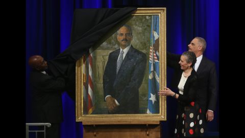 Holder and his wife, Sharon Malone, look on as artist Simmie Knox unveils Holder's official portrait during a ceremony at the Justice Department in Washington on Friday, February 27.