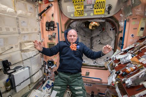 NASA astronaut Scott Kelly watches fresh carrots float in front of him on the International Space Station on Sunday, April 19. Scott is taking part in a one-year mission to test how the human body reacts to an extended time in space.