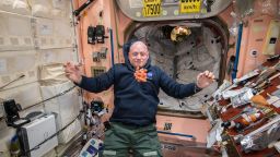 NASA astronaut Scott Kelly watches a bunch of fresh carrots float in front of him on board the International Space Station on April 19, 2015. Scott partaking in a one-year mission to test how the human body reacts to an extended time in space.