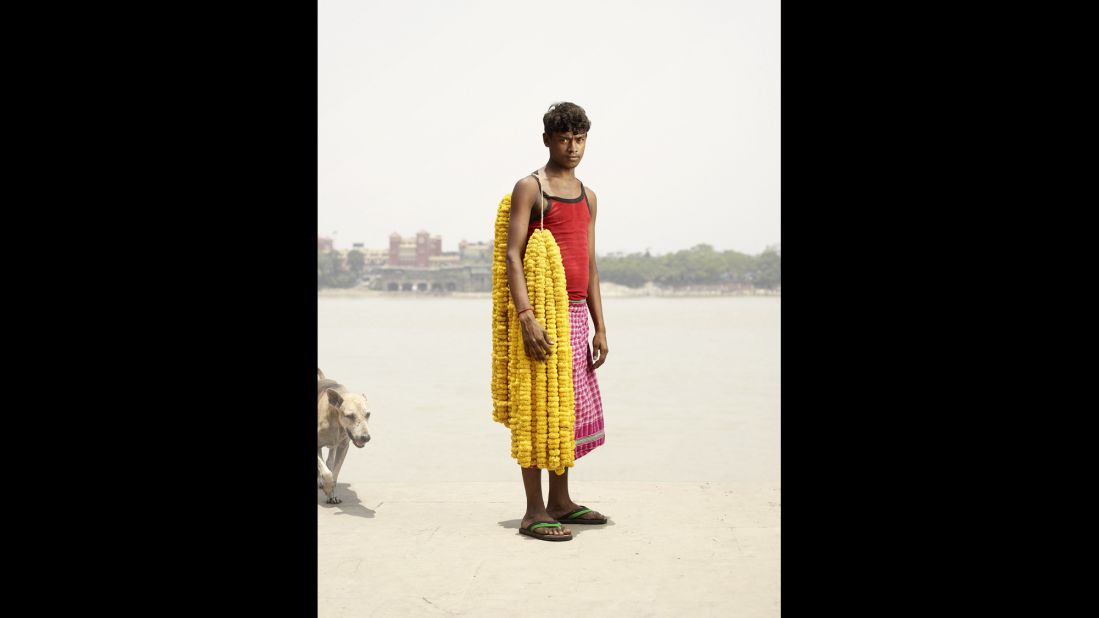 Chandan Kumar carries strands of gainda flowers on his shoulder.