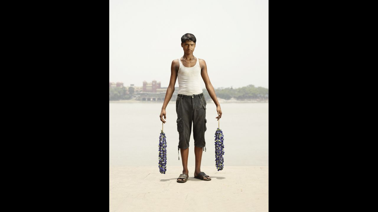 Hermann shot all the portraits between noon and 3 p.m., combining the hazy smog in the air, sunlight from above and studio lights of his own. Here, Rajesh Yadav holds strands of neelkanth flowers.