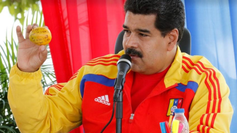 Venezuelan President Nicolas Maduro shows off the mango that a supporter threw at him. 