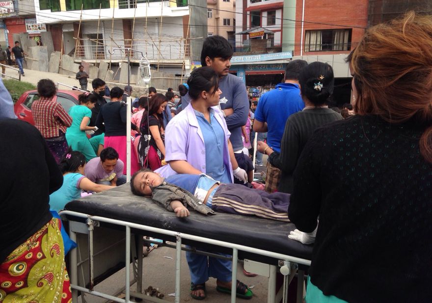 An injured child receives treatment outside Medicare Hospital in Kathmandu on April 25. Residents, after a relentless series of aftershocks, have been remaining outdoors.