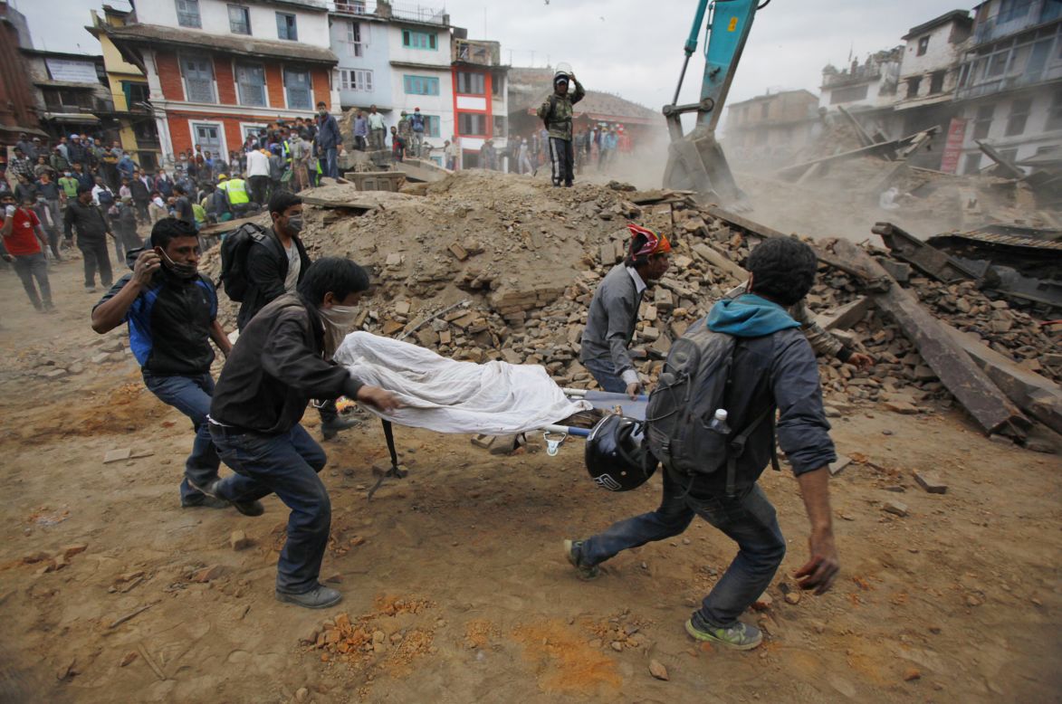 Volunteers carry a body recovered from the debris of a collapsed building in Kathmandu.
