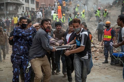 Emergency rescue workers carry a victim from Dharahara after the tower in Kathmandu collapsed on April 25. 