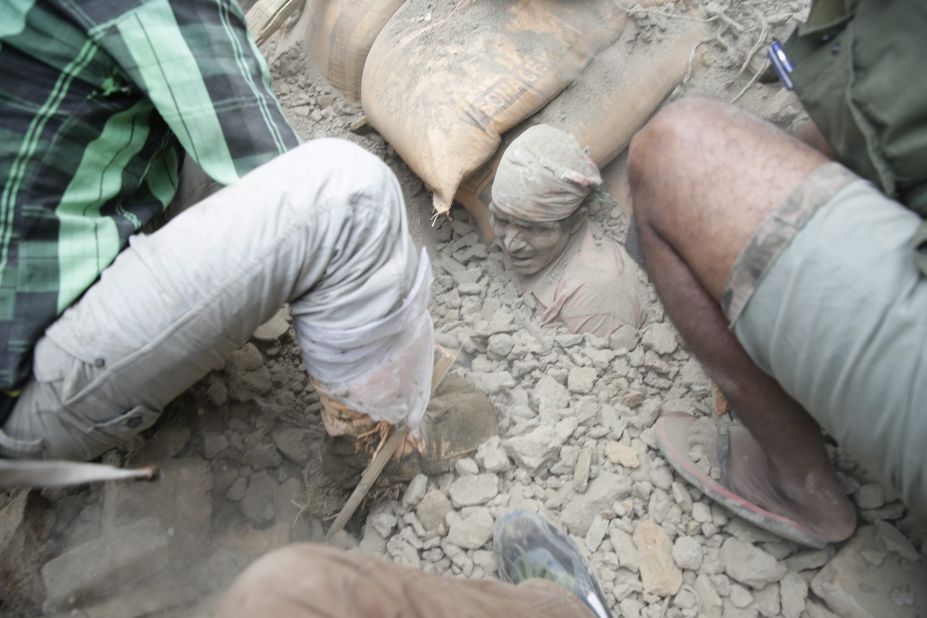 People try to free a man from the rubble in Kathmandu on April 25. Cheers rose from the piles when people were found alive -- but mostly bodies turned up. 