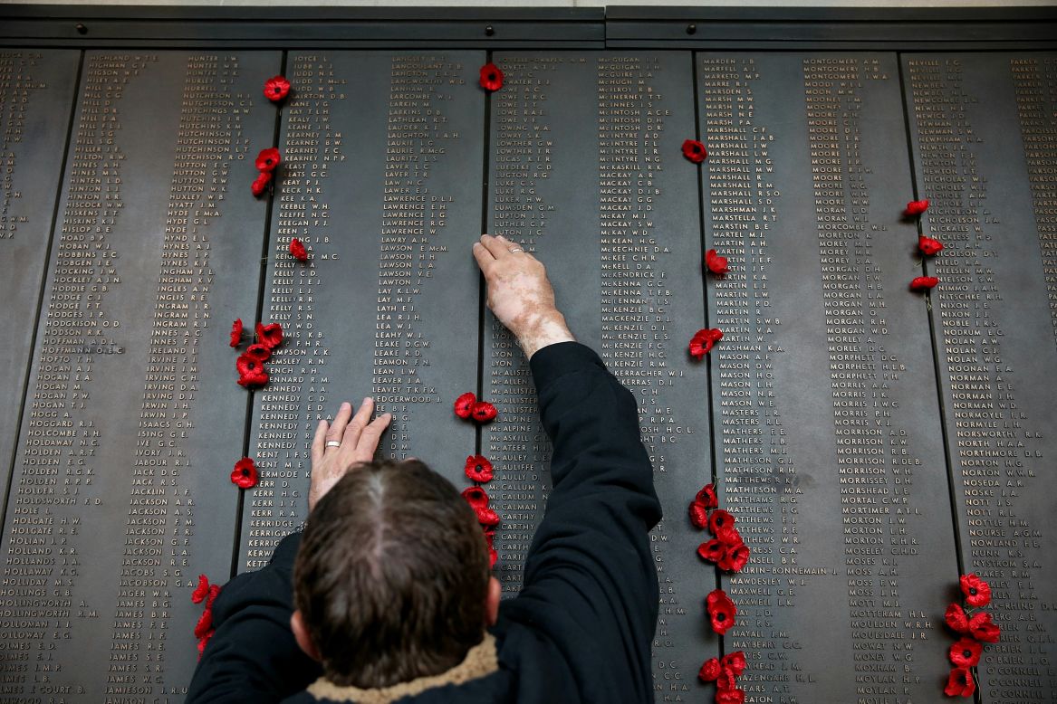 A man places a poppy on the Roll of Honor at the Australian War Memorial in Canberra, Australia.