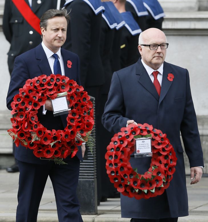 Britain's Prime Minister David Cameron, left, and George Henry Brandis, attorney general for Australia, carry wreaths during a ceremony at the Cenotaph in Whitehall, London, 