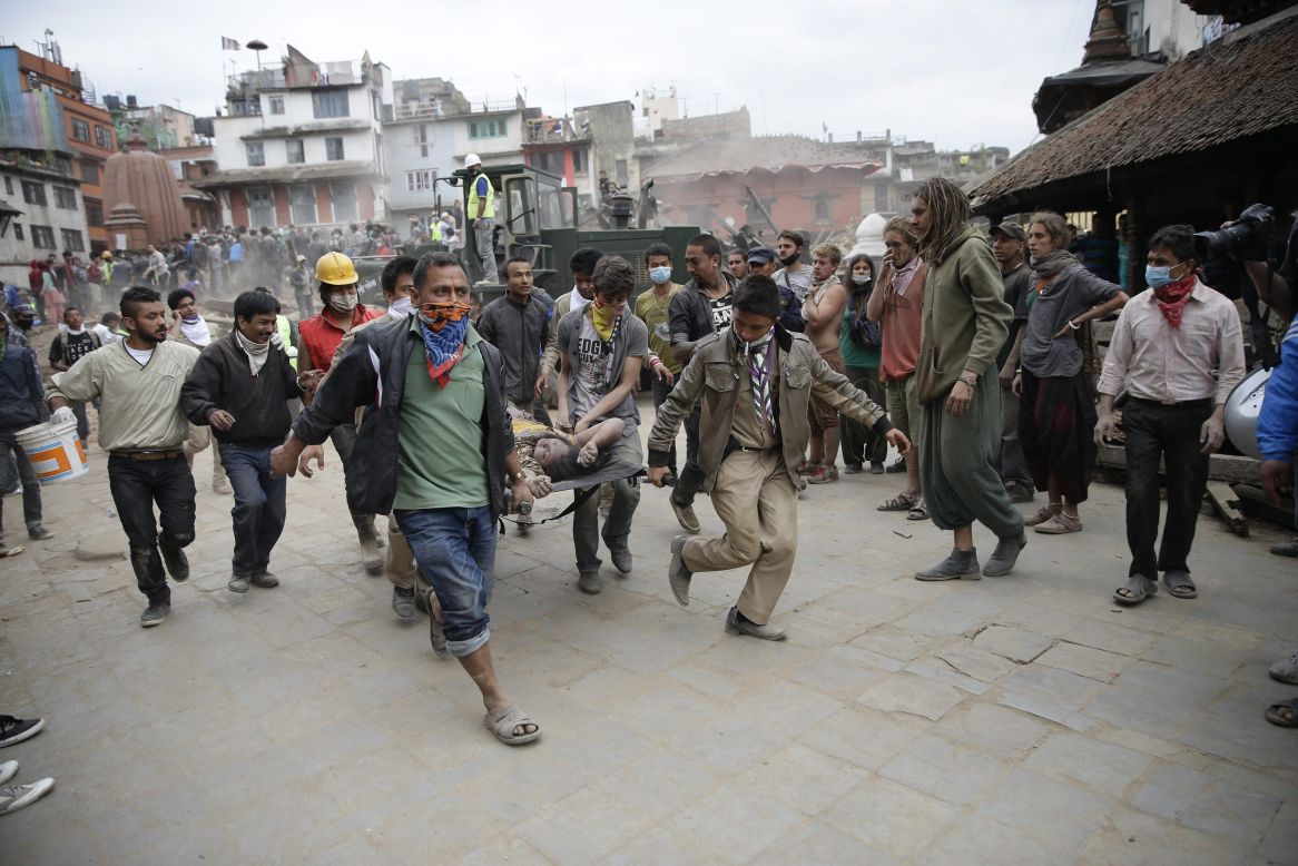 Civilian rescuers carry a person on a stretcher in Kathmandu on April 25.